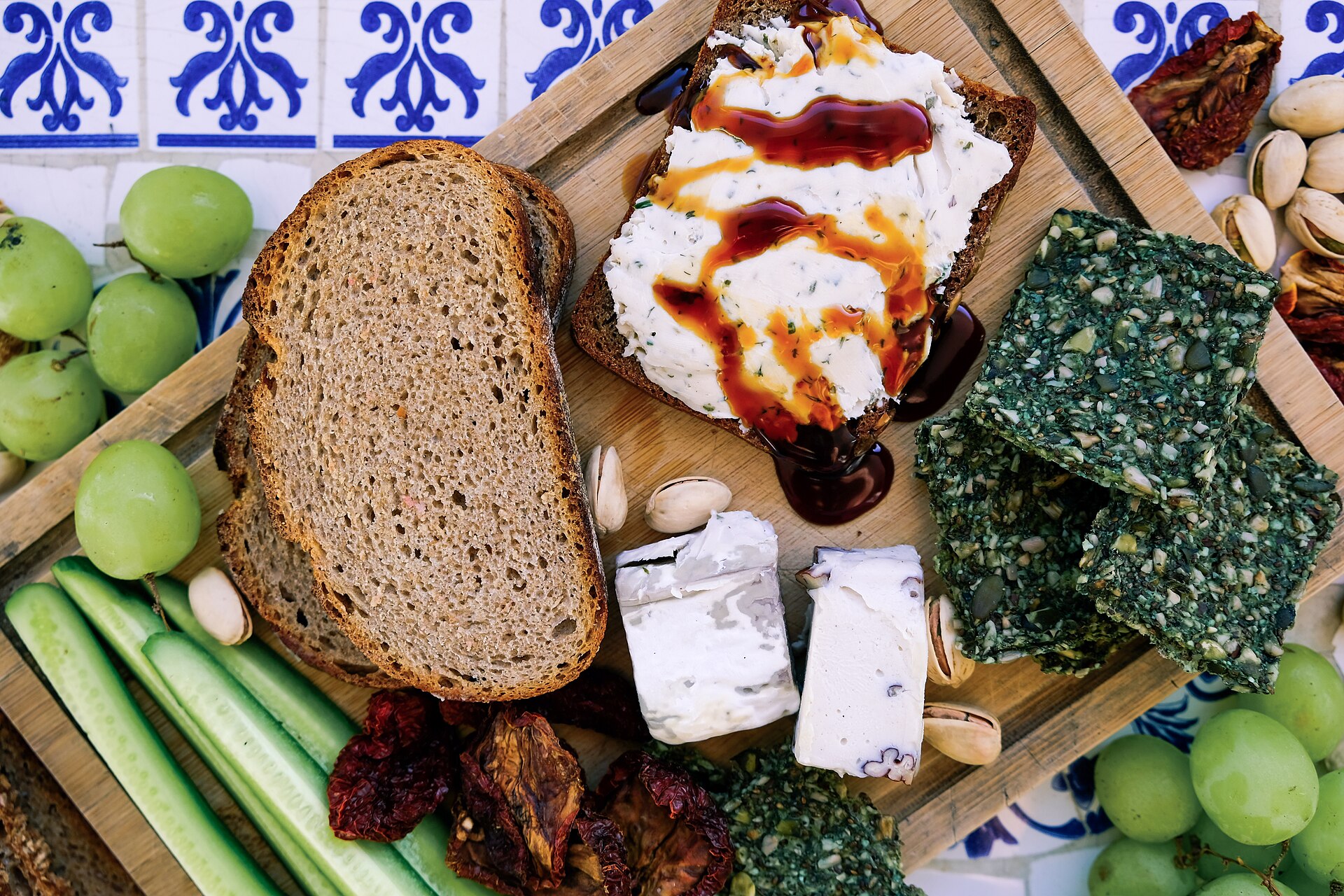 French-style cheese platter with bread, grapes, and balsamic-drizzled soft cheese